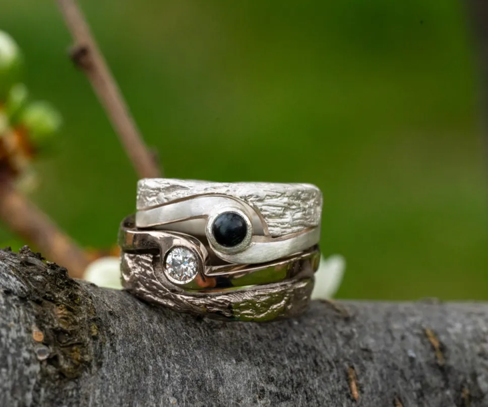 La bague la plus claire est en argent et la plus foncée en or blanc sertie d'un diamant